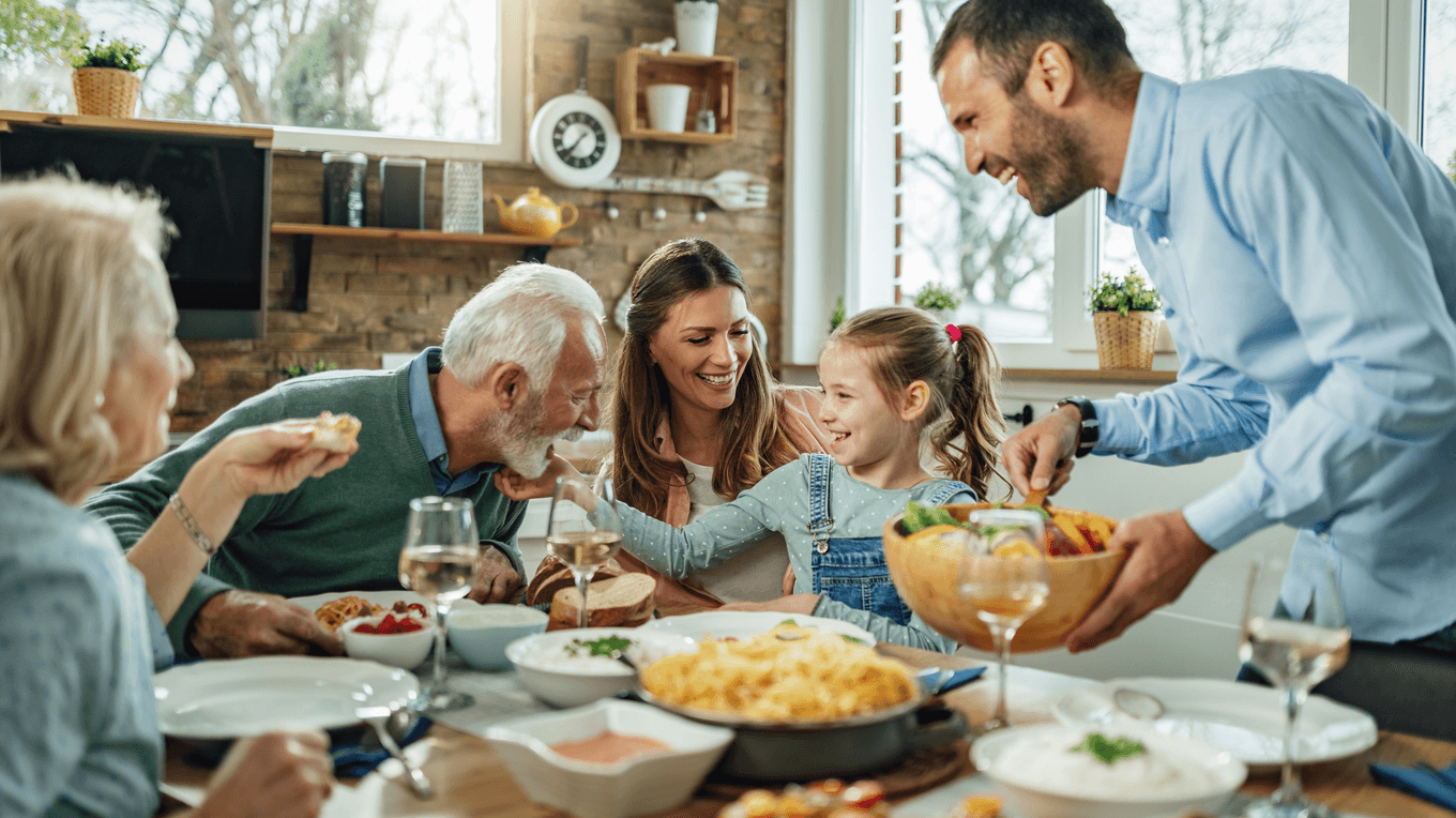 Родина жартує, спілкується та обідає за столом.